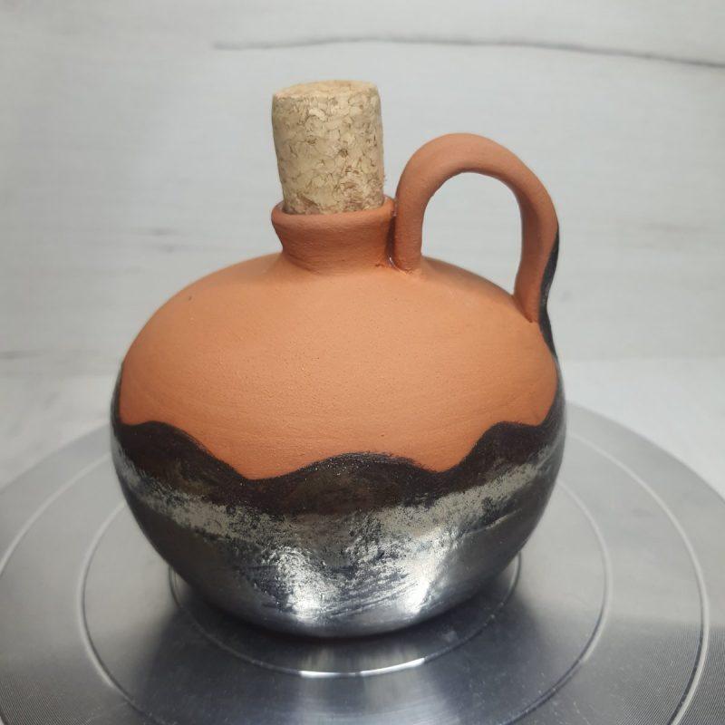 Ceramic mini jug "The breath of the earth, encased in the shine of metal"